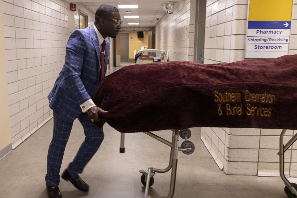 Diamante Jackson, 28, with Southern Cremation and Burial Services, rolls a body to his hearse at Carbondale Memorial Hospital Saturday, April 10, 2026, in Carbondale, Illinois, to prepare for cremation.