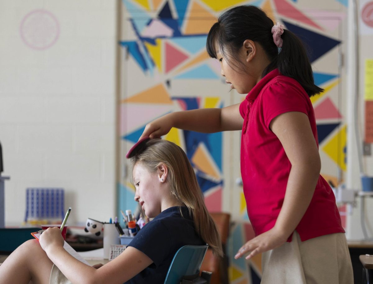 Fourth grader Rebecca Yang brushes Laurel Fehrenbacher's hair April 10, 2026 at St. Andrew's Catholic School in Murphysboro, Illinois.