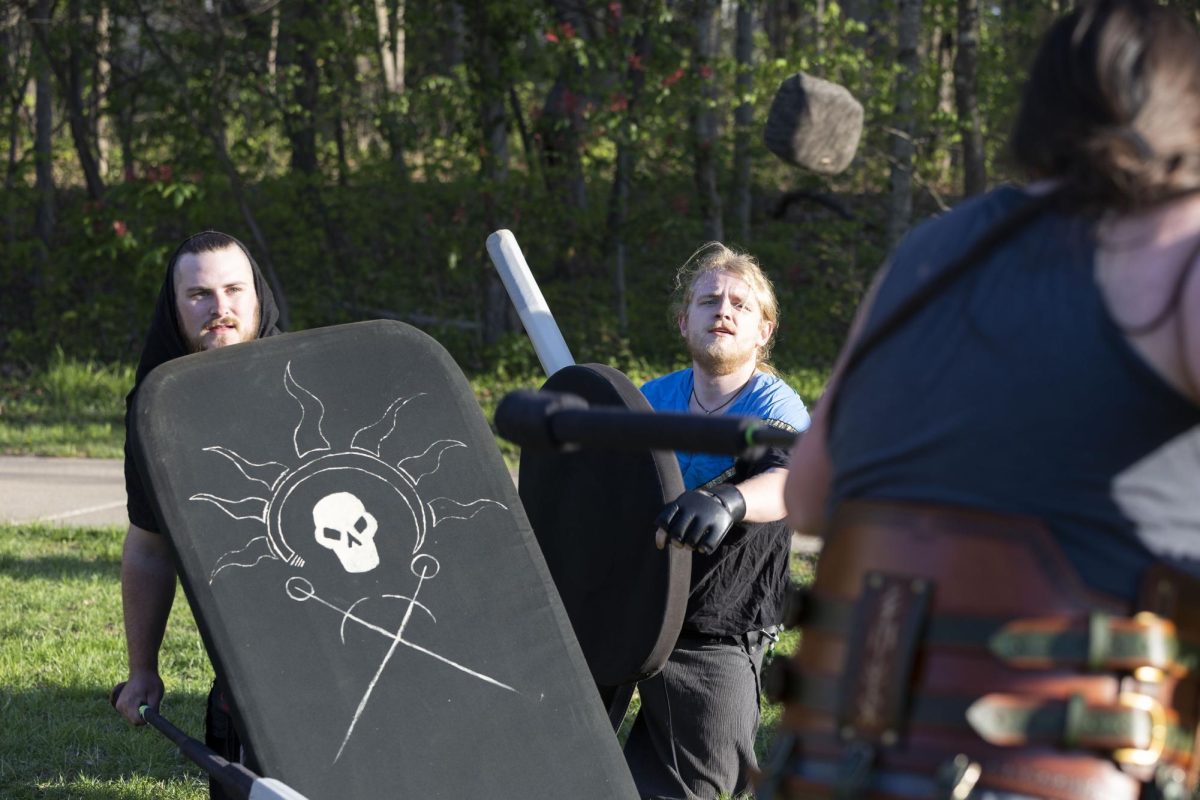 Ashton Reedy (Scarab) and Ben Herring (Bluejay) throw at rock towards Zach Rogers (Tater Stormcaller) April 7, 2026 in front of Morris Library in Carbondale, Illinois.