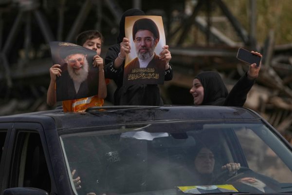 Displaced children hold portraits of the late Iran's Supreme Leader Ayatollah Ali Khamenei and his son the current leader Ayatollah Mojtaba Khamenei, as they return to their village following a ceasefire between Hezbollah and Israel, in Qasmiyeh near the city of Tyre, south Lebanon, Friday, April 17, 2026. 
