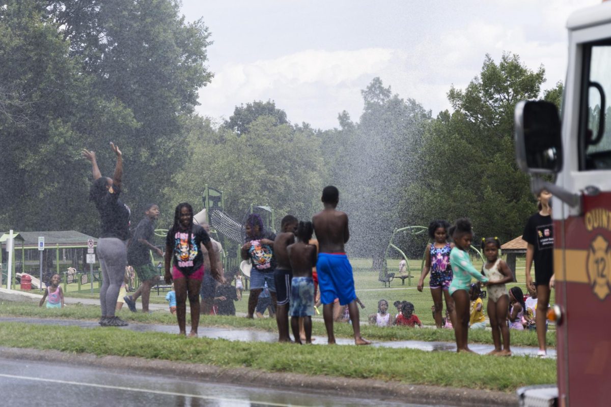 Kids and parents gather at Attucks Park to cool off from the water spraying out of the firetruck hose July 22, 2026  in Carbondale, Illinois. Peyton Cook | @cookmeavisual
