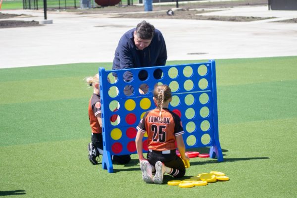 Gov. JB Pritzker plays Connect 4 with children following an event to open a new sports park in Springfield on April 28, 2026. (Capitol News Illinois photo.)