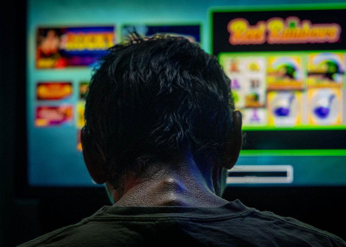 A man spends the last three dollars in his pocket playing a bar slot machine in downstate Golconda on June 4, and then leaves. (Credit: Julia Rendleman for Capitol News Illinois)